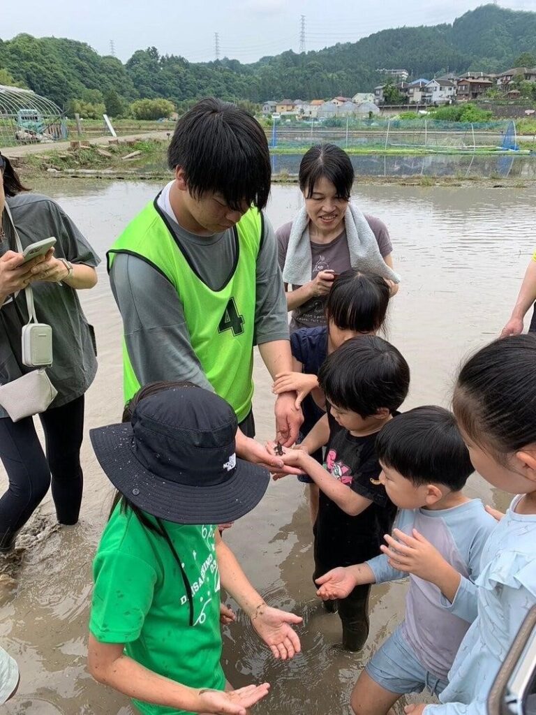 カエルを見せる高校生に子どもたちも集まります