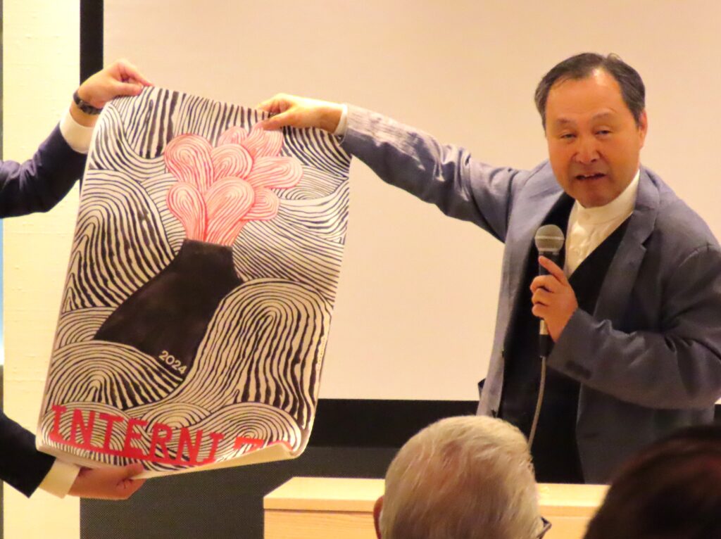 喜多俊之氏が富士山をデザインしたポスターを紹介するオーパスの今城社長