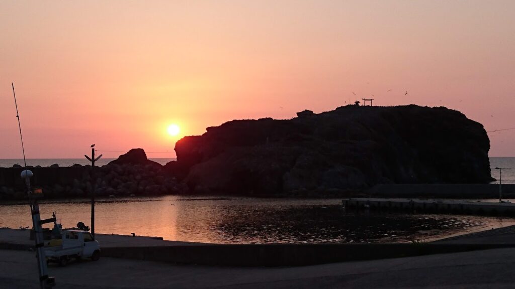 沈みゆく夕日と「経島（ふみしま）」