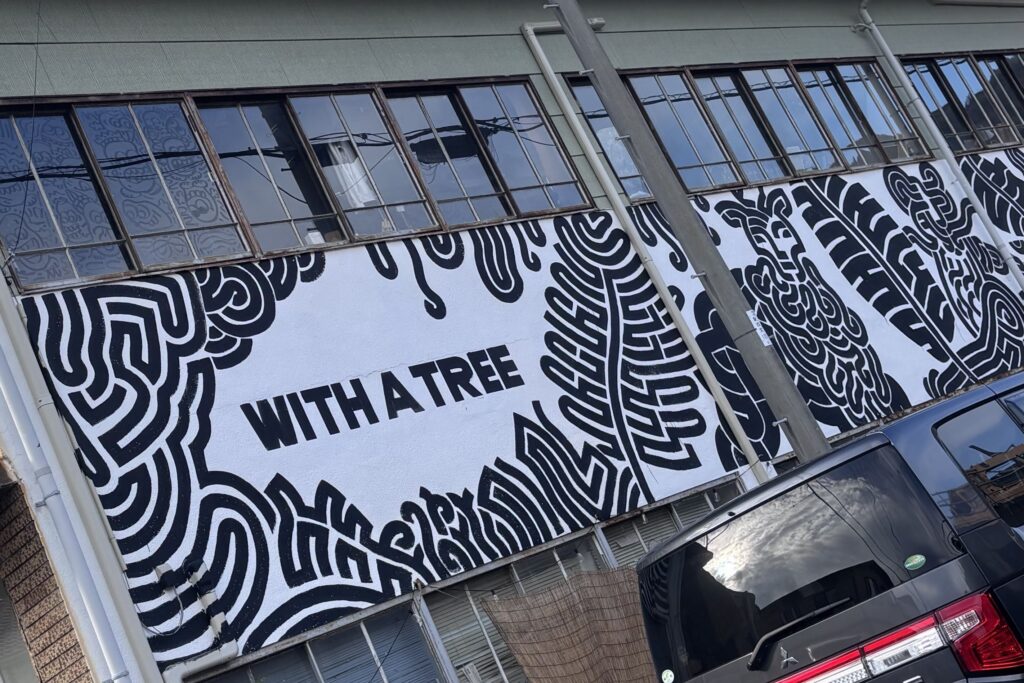 入り口脇の看板も出入りするアーティストが手掛けている。